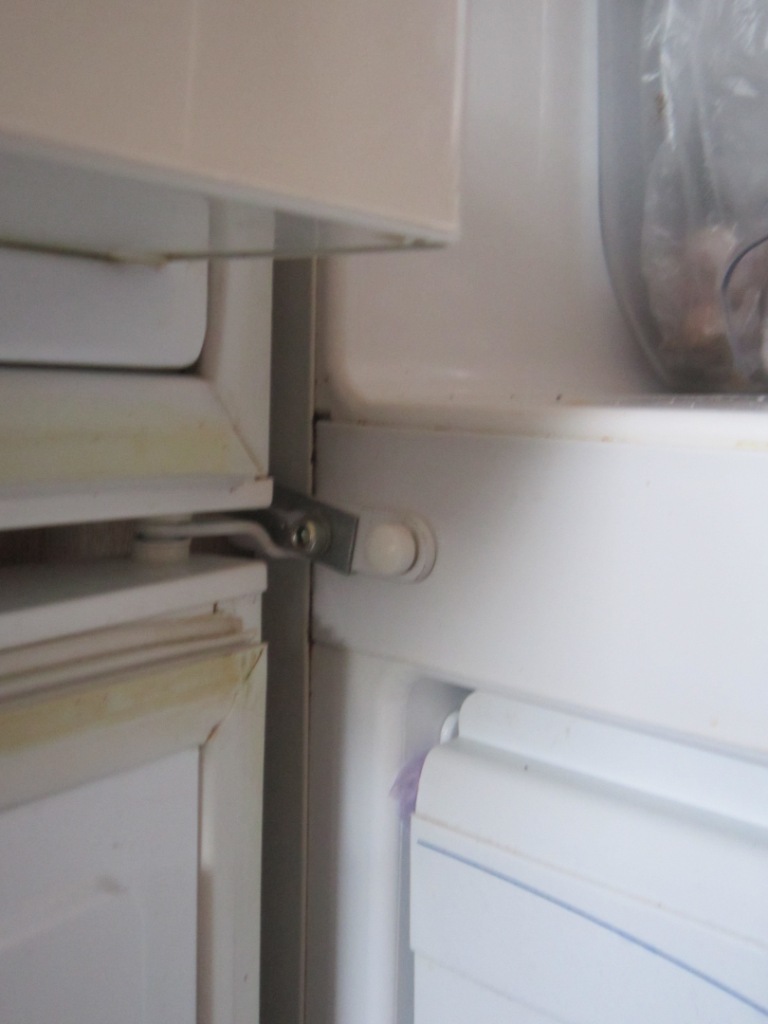 Второй стороной уголок крепится к холодильнику в том месте, где крепится упор для двух дверей.